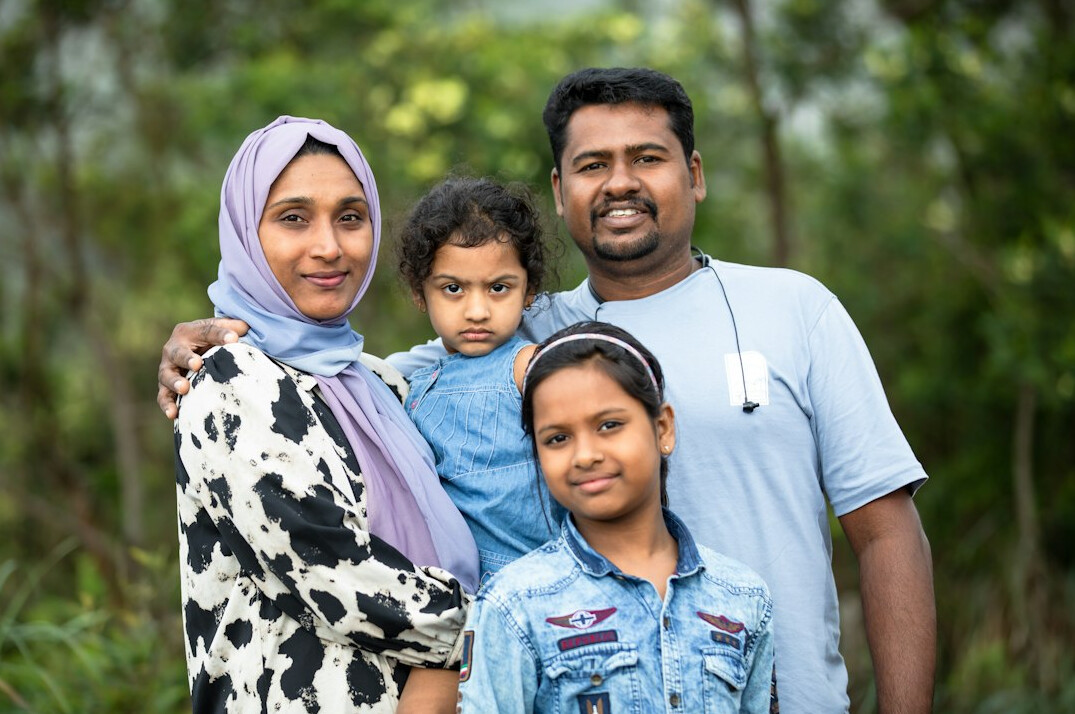 Group of four diverse Malaysian professionals standing together smiling